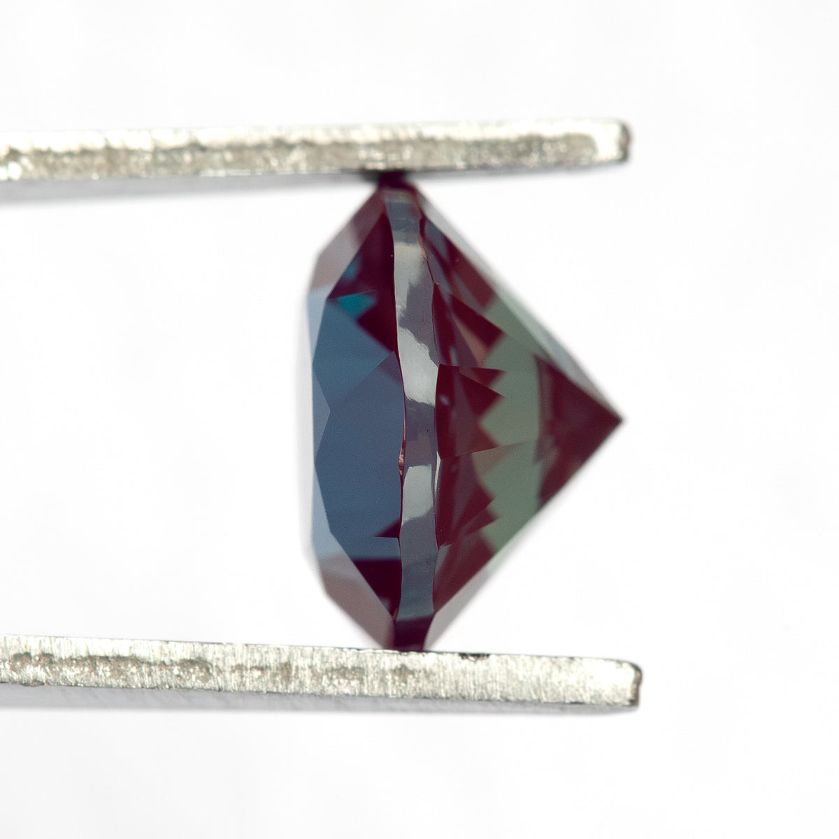 Round sample seen from the side in tweezers, showing pavilion depth.
