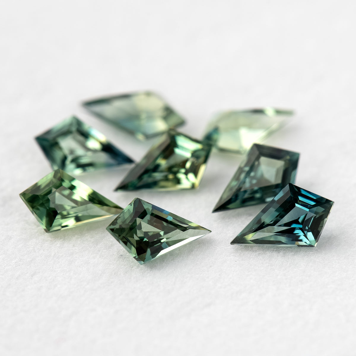 Macro view of the original group, including a darker teal sapphire at the front.
