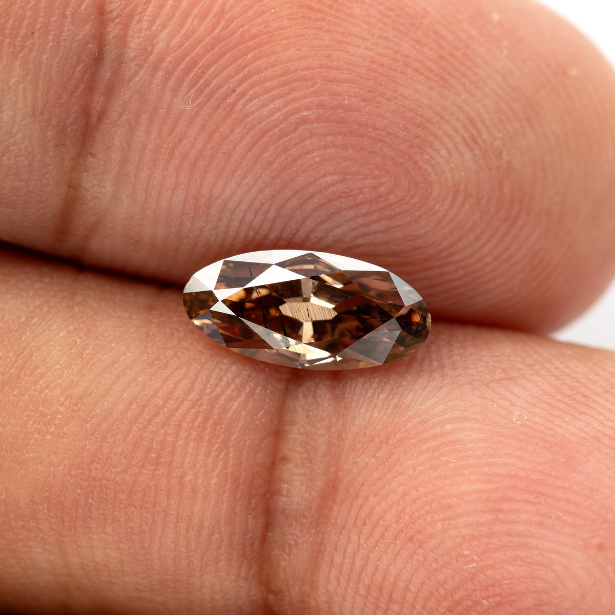 1.43 ct pinkish-brown lab-grown elongated oval diamond, finger face-up scale, SKU BLD154