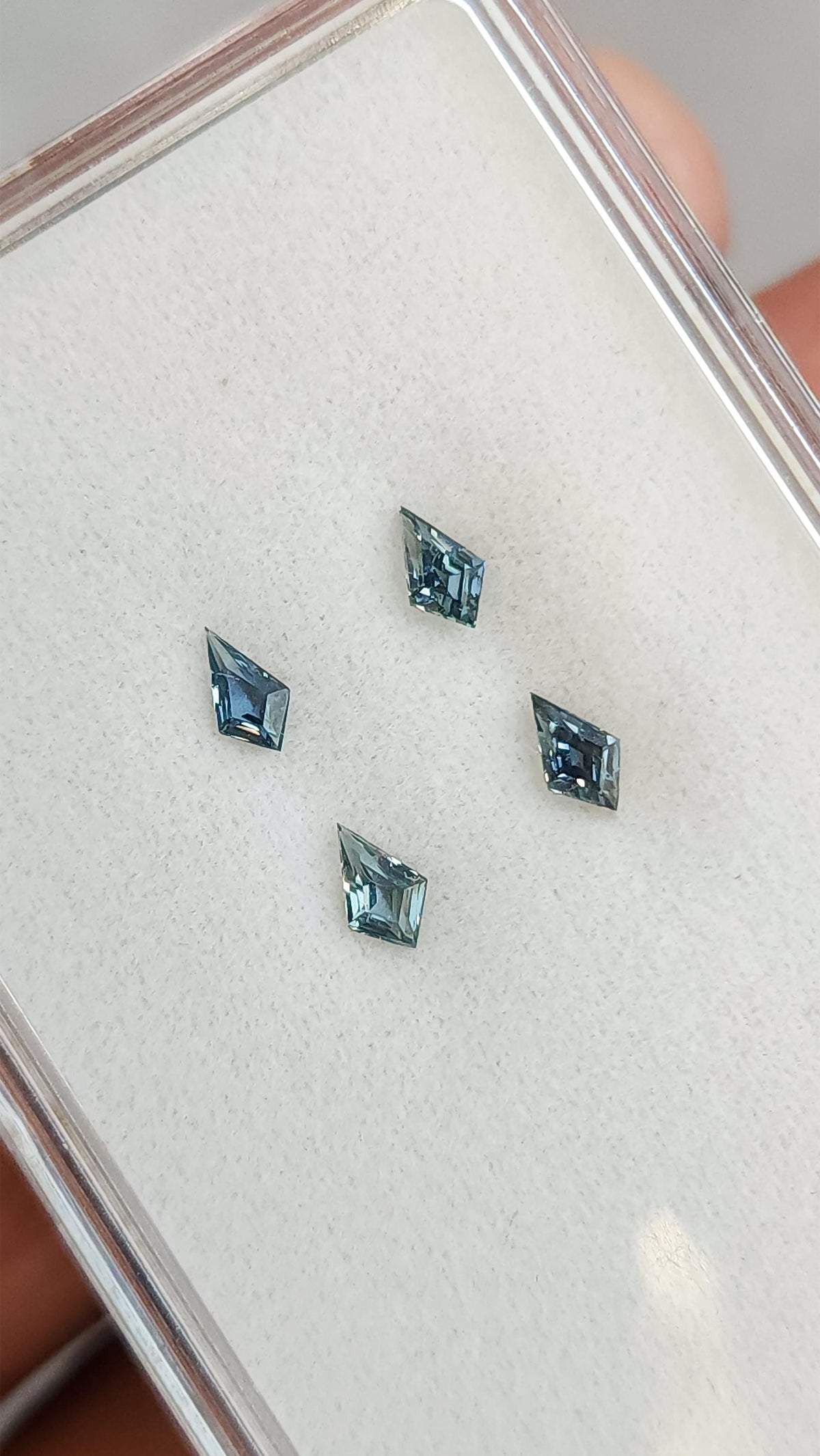 Four kite-shaped teal sapphires viewed face-up. View 8.