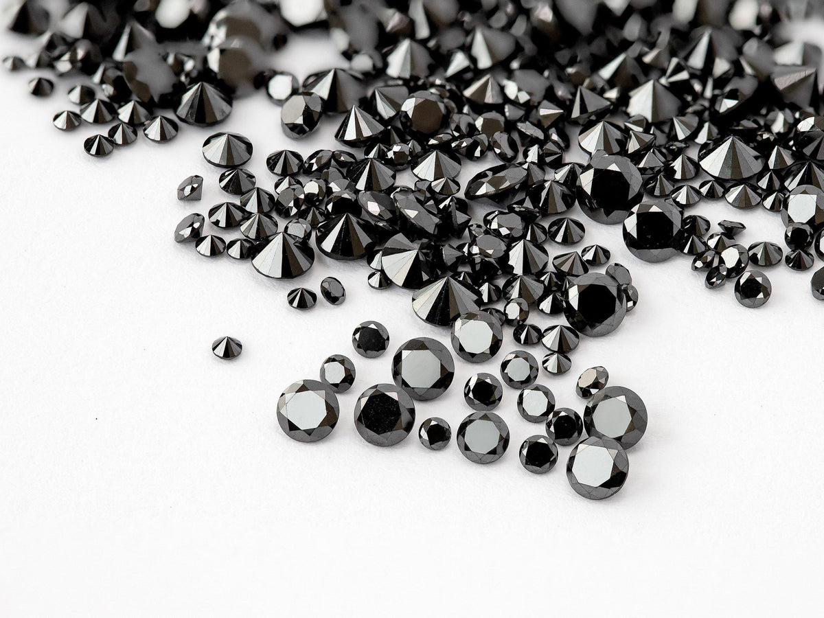 Representative natural black round brilliant diamond melee in mixed face-up and reverse views; color enhanced.