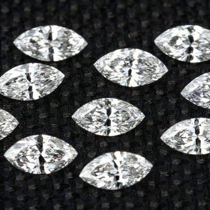 Group of calibrated 4 x 2 mm natural marquise diamonds on black fabric.
