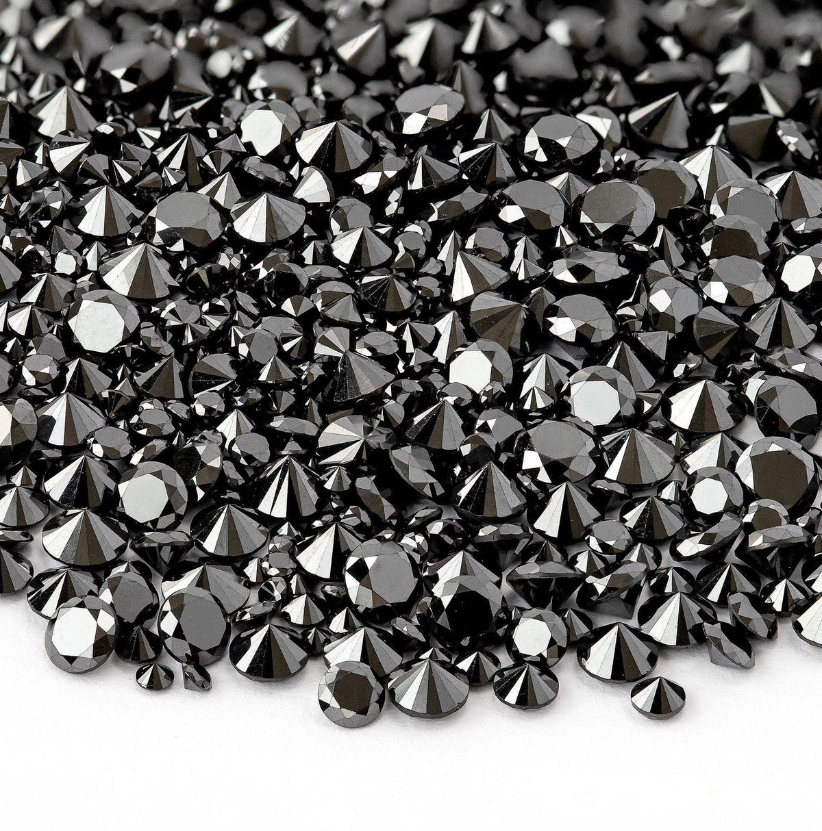 Macro view of representative color-enhanced natural black diamond melee with round brilliant faceting.