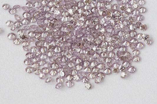 Close view of representative 1mm natural purple-pink round diamond stock on a white background.