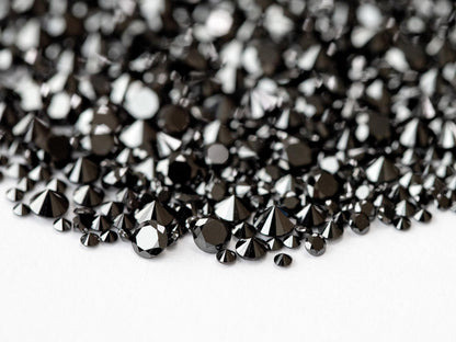 Close macro of representative black diamond melee showing round brilliant crowns and dark reflections.
