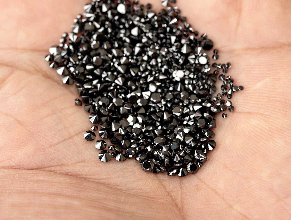 Representative natural black diamond melee held in hand for scale; selected size and pack are supplied.