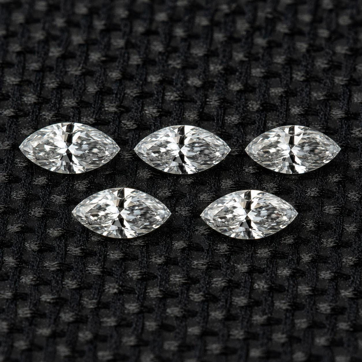Five matched 4 x 2 mm natural marquise diamonds arranged as a set.
