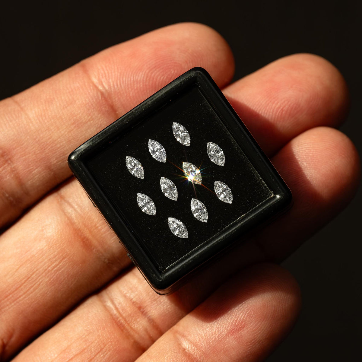 Hand-held gem box providing scale for calibrated 4 x 2 mm marquise diamonds.