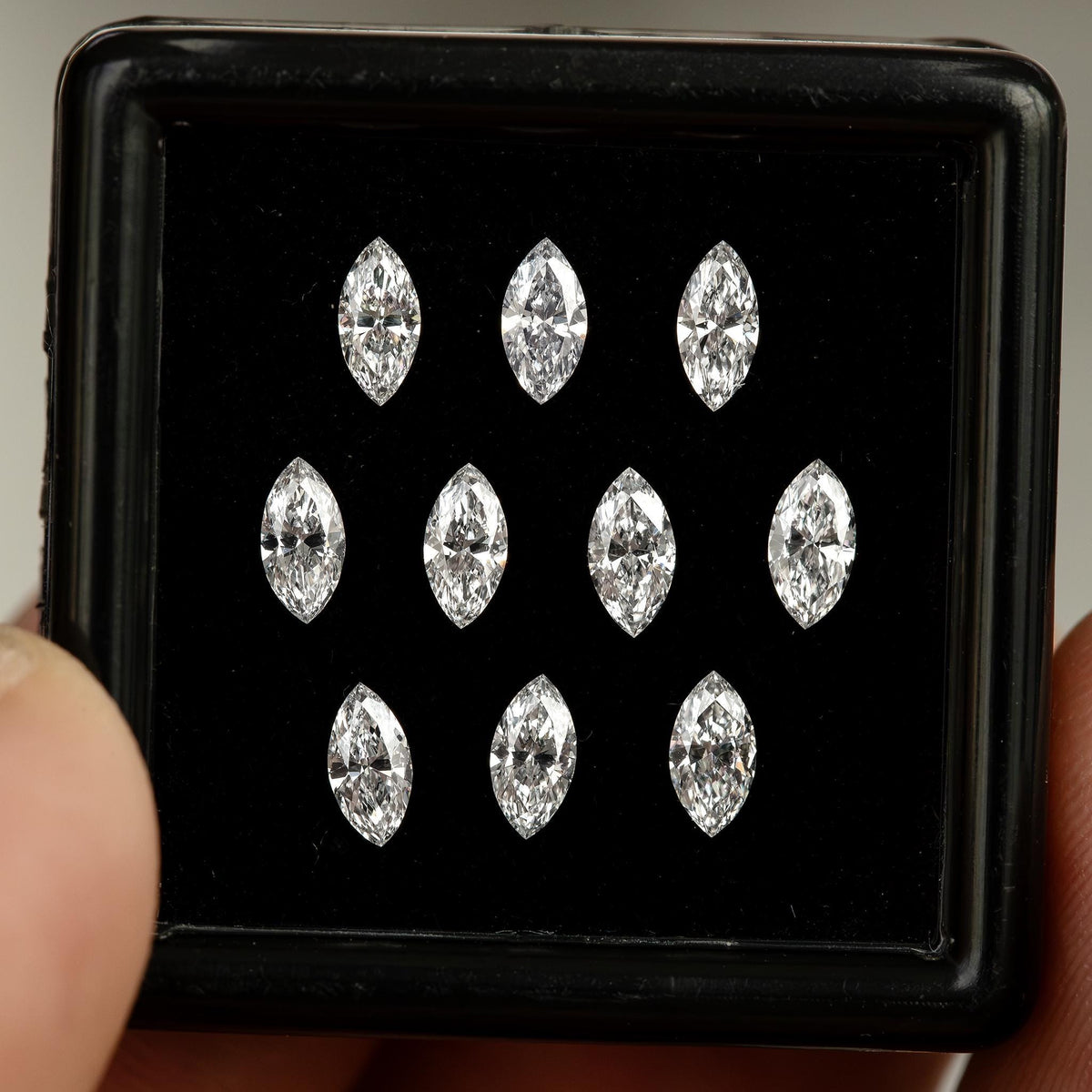 Front view of calibrated natural marquise diamonds arranged in a gem box.