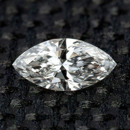 One 5x2.5 mm marquise natural diamond photographed face-up on black woven fabric, showing its pointed outline and brilliant facets.