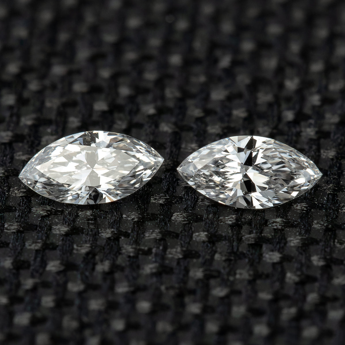 Two face-up marquise diamonds side by side on black woven fabric, illustrating the matched-pair selection.