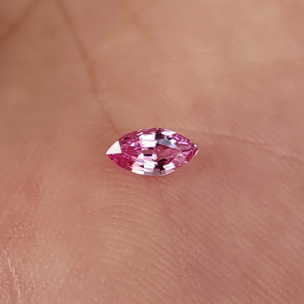 Marquise sapphire on a palm with its long axis horizontal and both pointed tips visible.