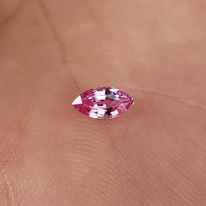 Marquise sapphire on a palm with its long axis horizontal and both pointed tips visible.