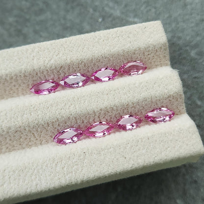 Low angled view of the eight marquise sapphires, with pale reflections on their central facets.
