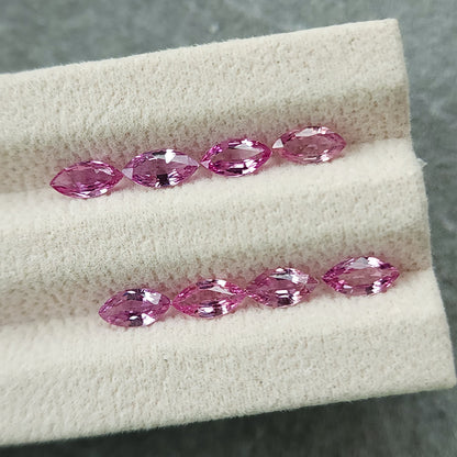 The eight pink sapphires in two horizontal rows, viewed close to the grooved display pad.