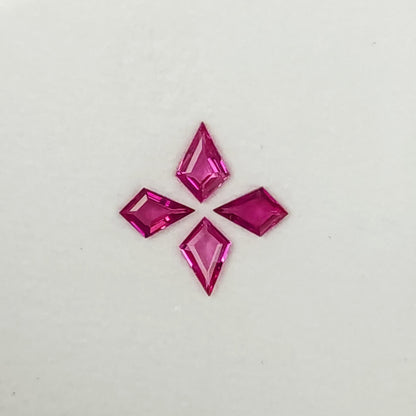 Close alternate face-up view of the four pink kite rubies, showing their central facets and varied outlines.