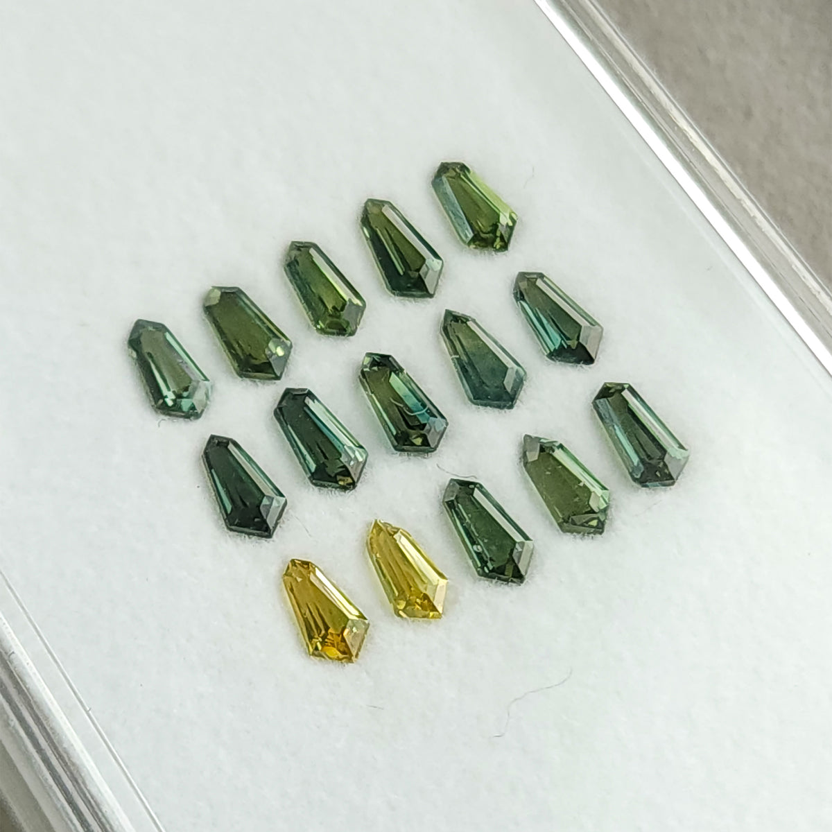 Close tilted view of the sapphire rows, showing green and yellow reflections.