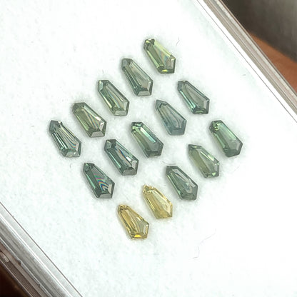 Tilted sapphire tray with brighter pale reflections across some green stones.