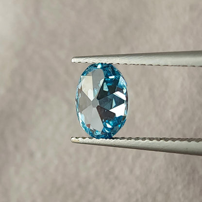 Alternate rotated tweezers view of the oval diamond with pale reflections.
