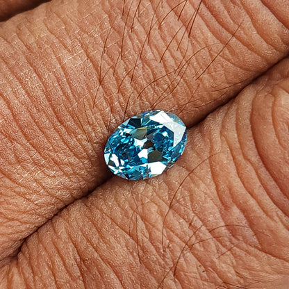 Wider palm view of the blue oval diamond with its full outline visible.