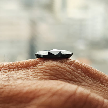 Low side-profile view of the black marquise diamond on a hand, showing the raised faceted crown.