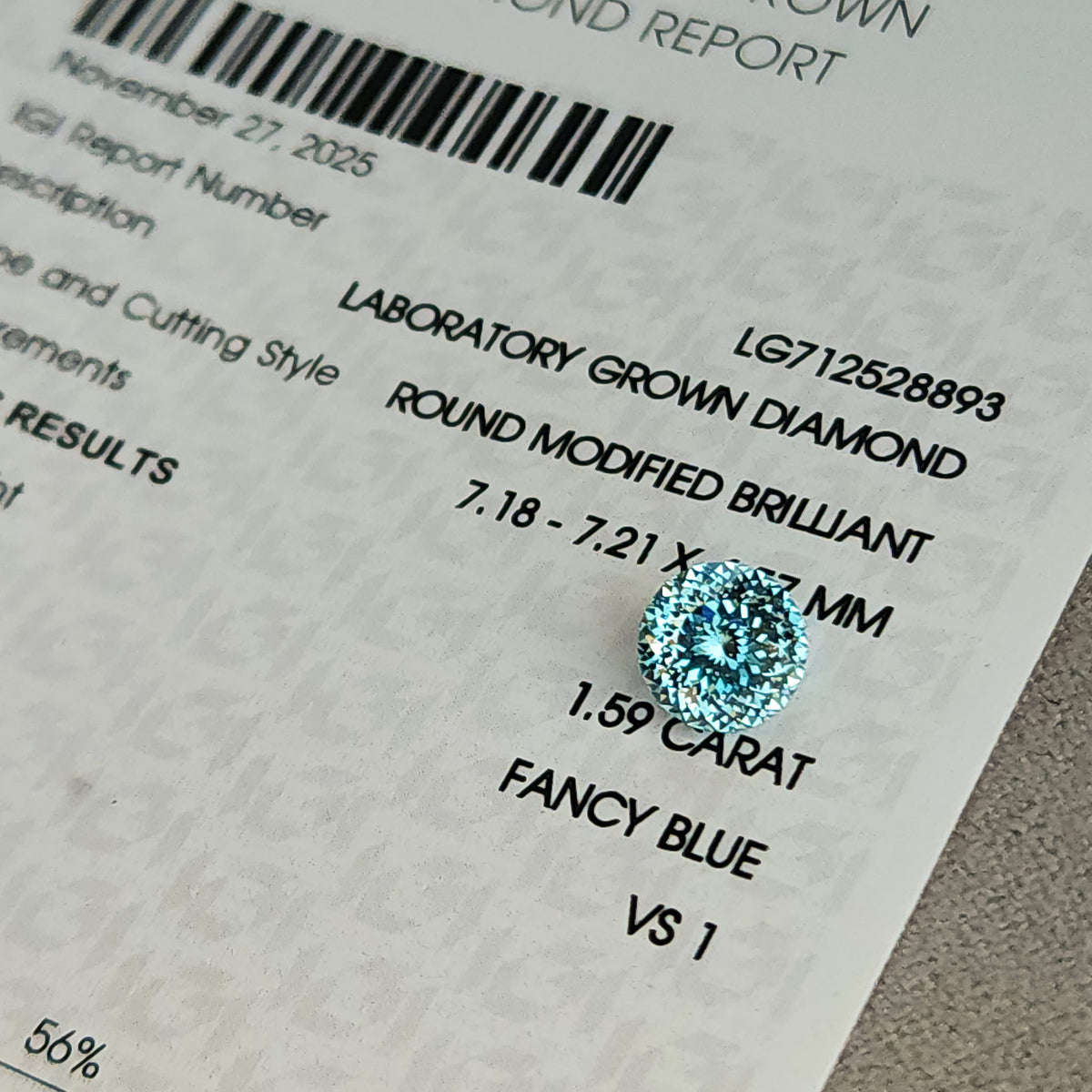 Blue round diamond on IGI report LG712528893; visible text reads 1.59 carat, Fancy Blue, VS1 and Round Modified Brilliant. The stone covers part of the measurement line.