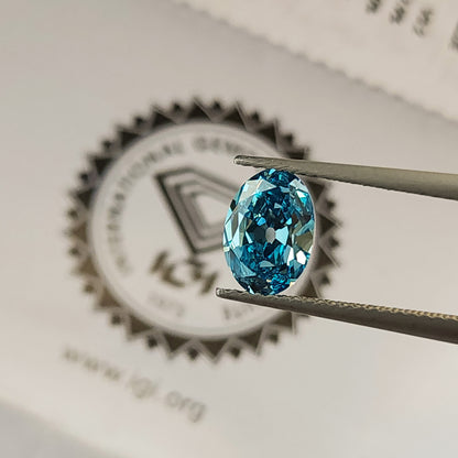 Blue oval diamond held in tweezers above the IGI logo on its report.