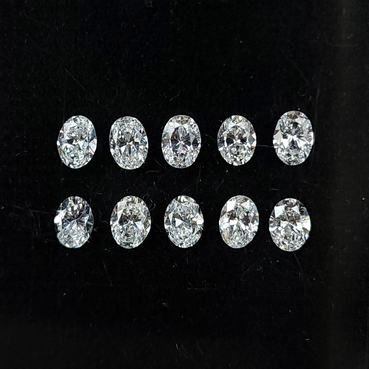 Ten oval brilliant diamonds arranged face-up in two rows on black backing.