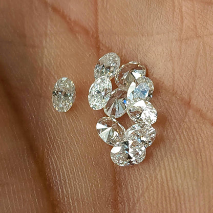 Loose oval diamonds resting on a hand in mixed orientations.