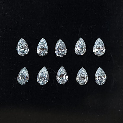 Ten representative pear brilliant diamonds arranged crown-up in two rows on black backing; sold per stone.