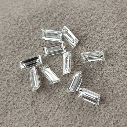 Representative natural baguette step-cut diamonds arranged on gray fabric.