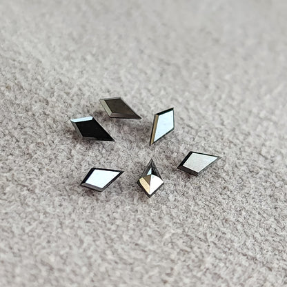 ニュートラルな背景に並べた、規格サイズの代表的なカイト形ブラックダイヤモンド。