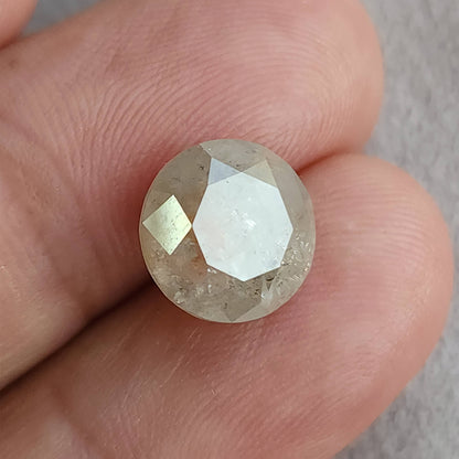Round diamond on fingertips with a large pale table reflection, showing its circular outline and size relative to the finger.