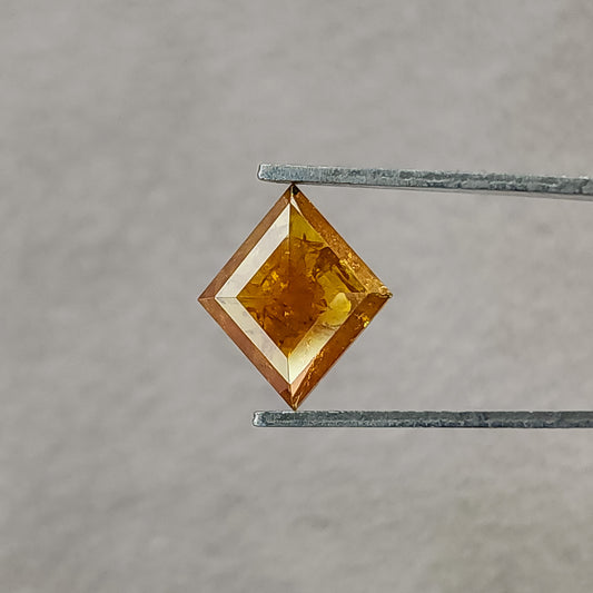Orange kite-shaped rose-cut diamond held face-up in tweezers against gray, with bright border facets and visible inclusions.