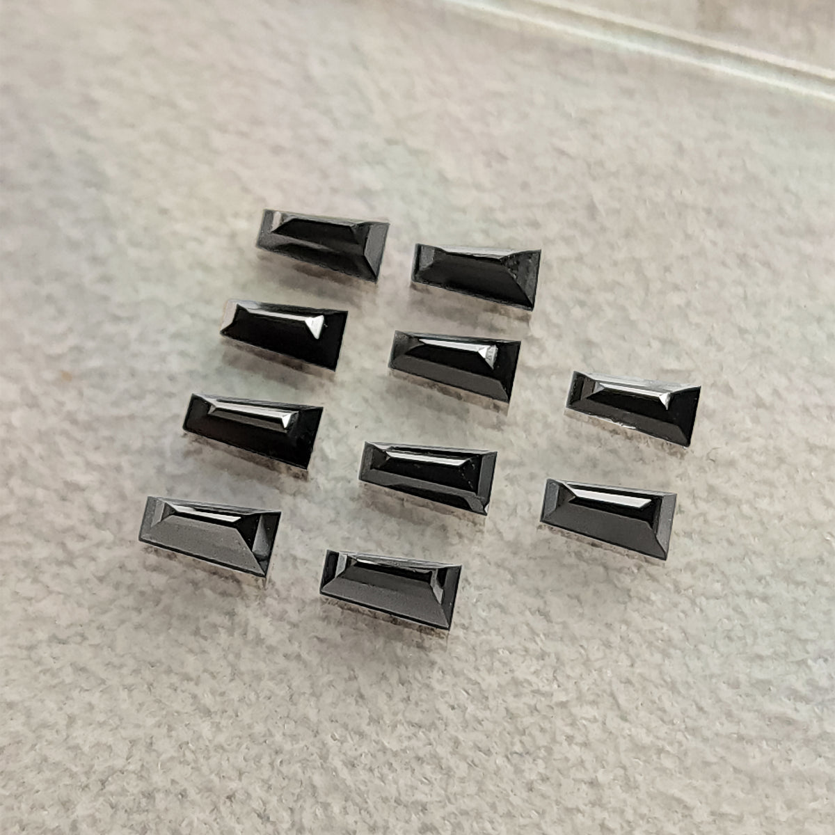 A loose group of black tapered diamonds viewed at an oblique angle.