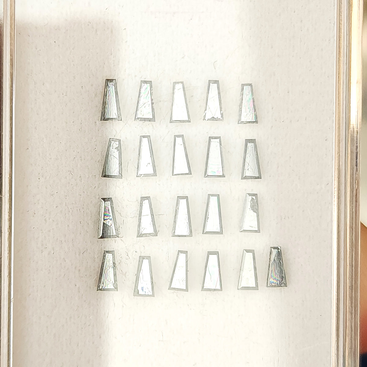 Tapered baguette diamonds reflecting from silvery gray to dark gray as the viewing angle changes.