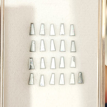 Tapered baguette diamonds reflecting from silvery gray to dark gray as the viewing angle changes.