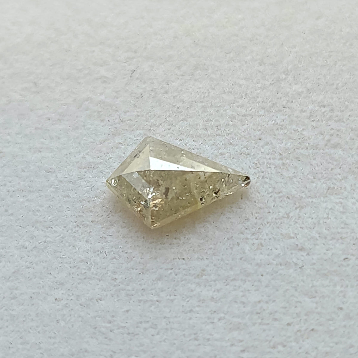 Angled face-up view of the untreated kite rose-cut diamond, showing its geometric outline and salt and pepper pattern.