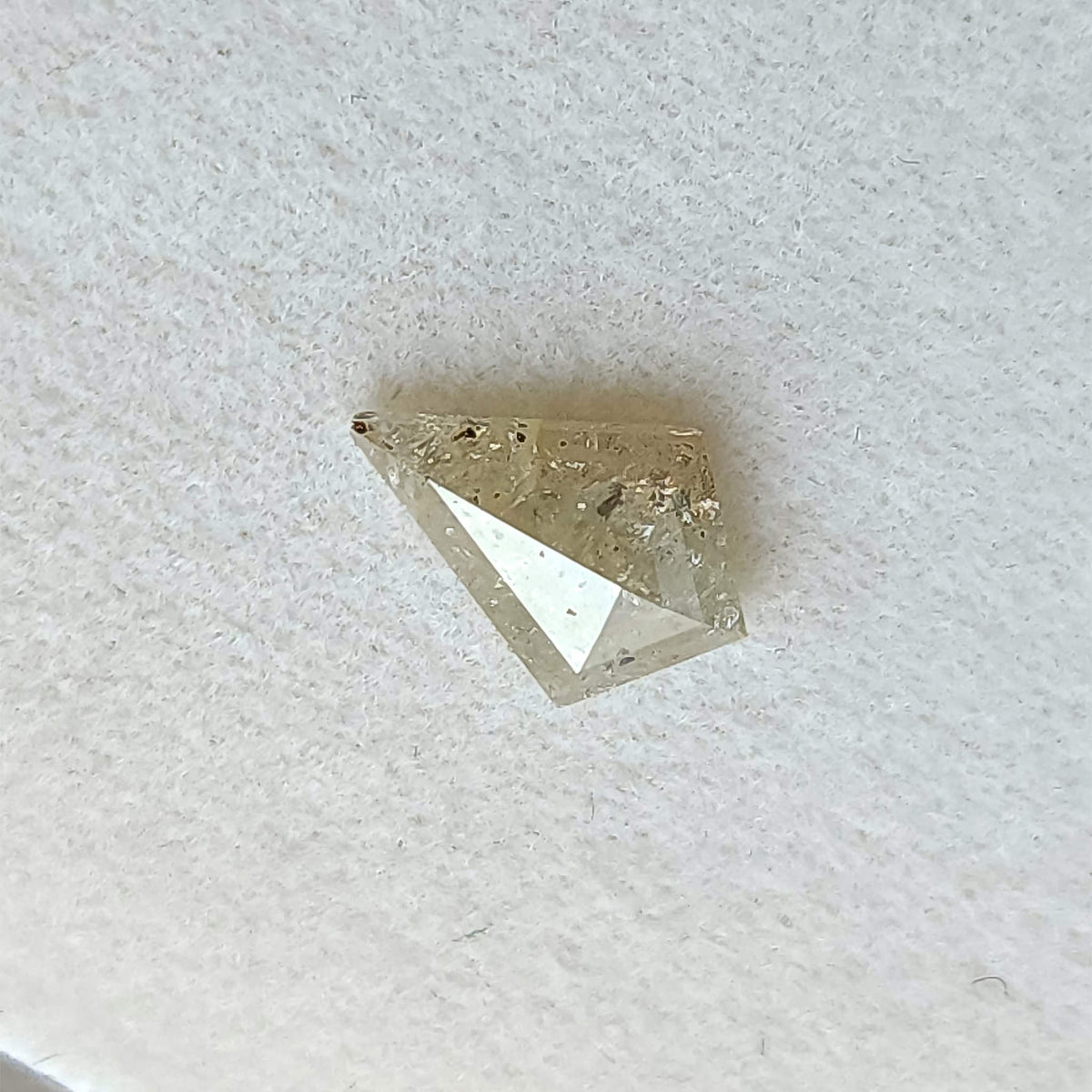Tilted view of the kite rose-cut diamond, with changing reflections across its broad facets.