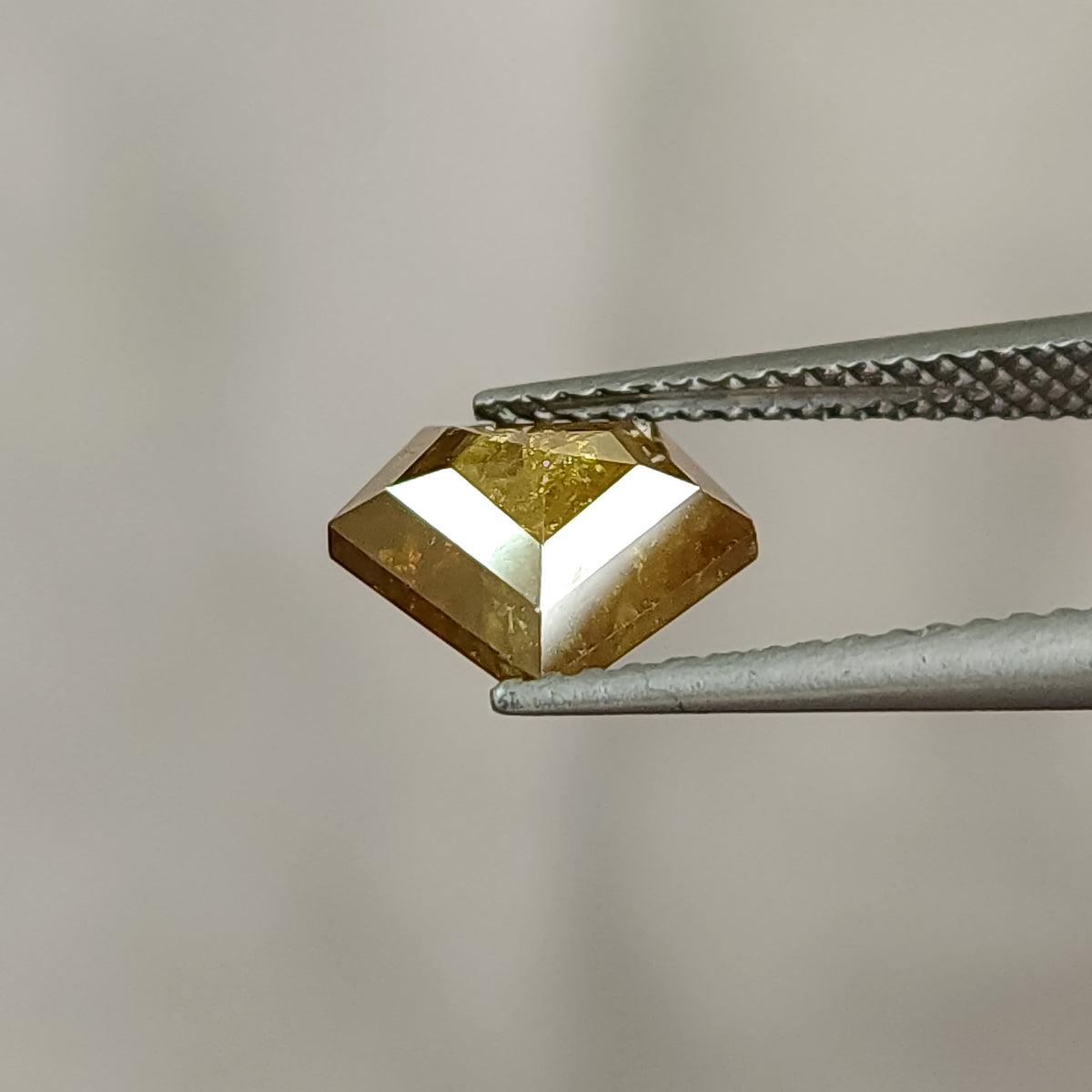 Low tilted profile view of the two-sided shield diamond, showing its depth and polished edge rather than a full face-up outline.