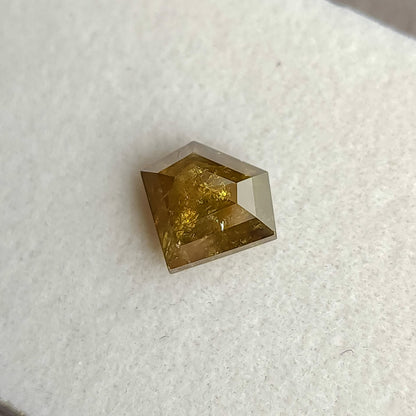 Oblique view of the warm yellow-brown shield diamond, showing its pointed lower edge and side profile.