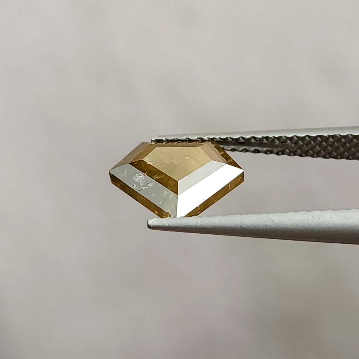 Tilted view of the shield diamond with bright reflections across one usable side and visible internal features.