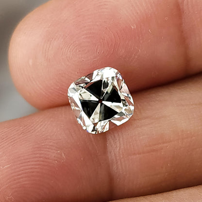 Top-down view of square cushion cut diamond on fingers displaying open culet and facet symmetry.