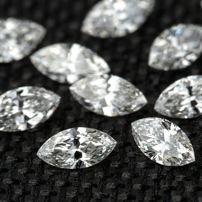 Close view of marquise diamonds on black fabric with the foreground stone in sharp focus and others behind it.