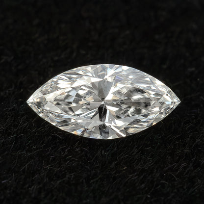 Single marquise diamond on black velvet, seen face-up with broad bright facet reflections.