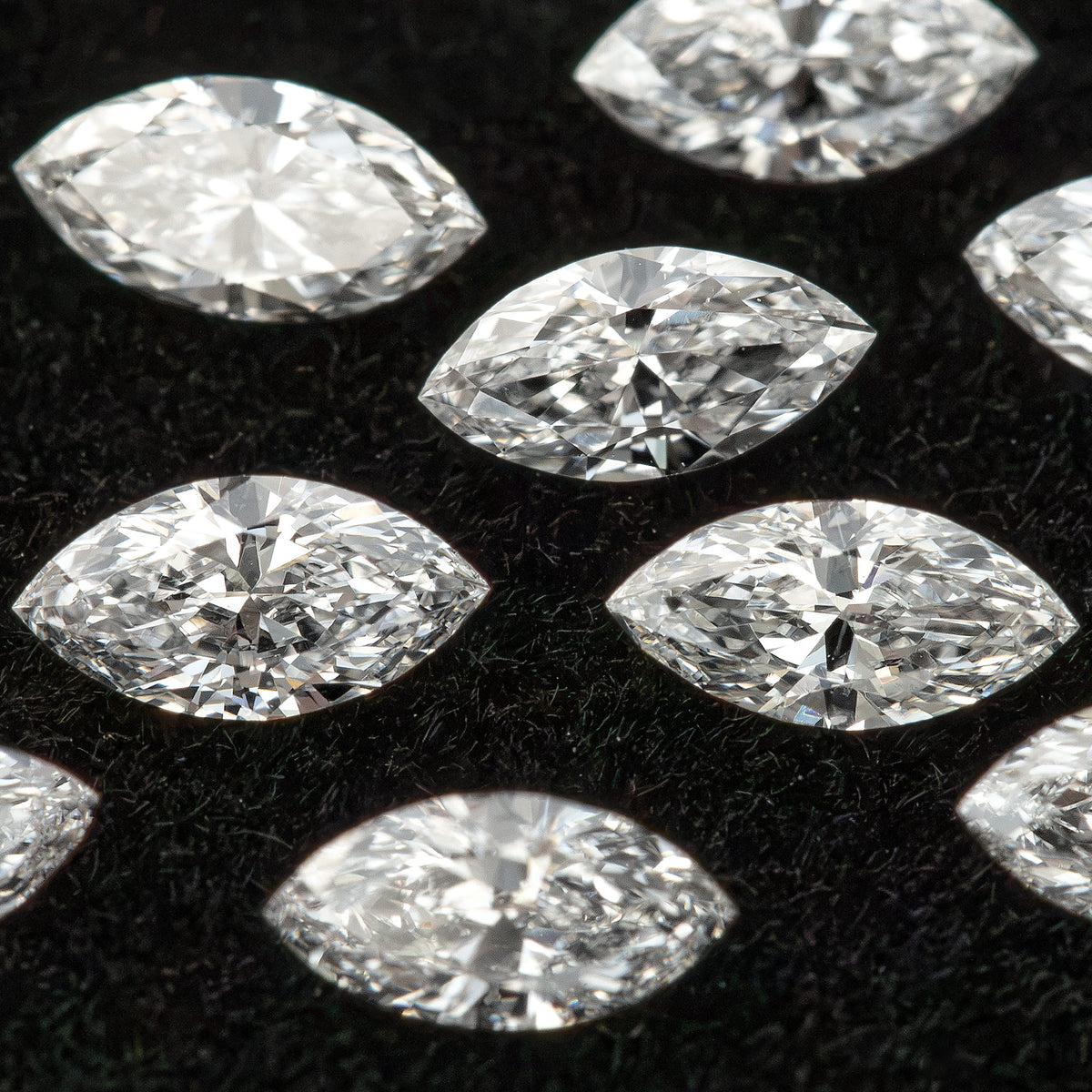 Tightly framed group of marquise diamonds on dark velvet, with several stones partly outside the frame.