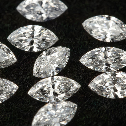 Close marquise-diamond group on black velvet showing mixed angles, pointed outlines and reflective facet patterns.
