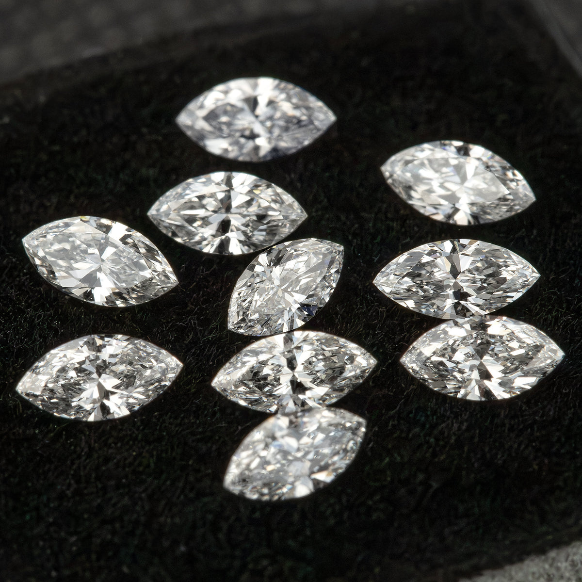 Loose marquise diamonds arranged across black velvet, showing the range of reflected patterns within the reference parcel.