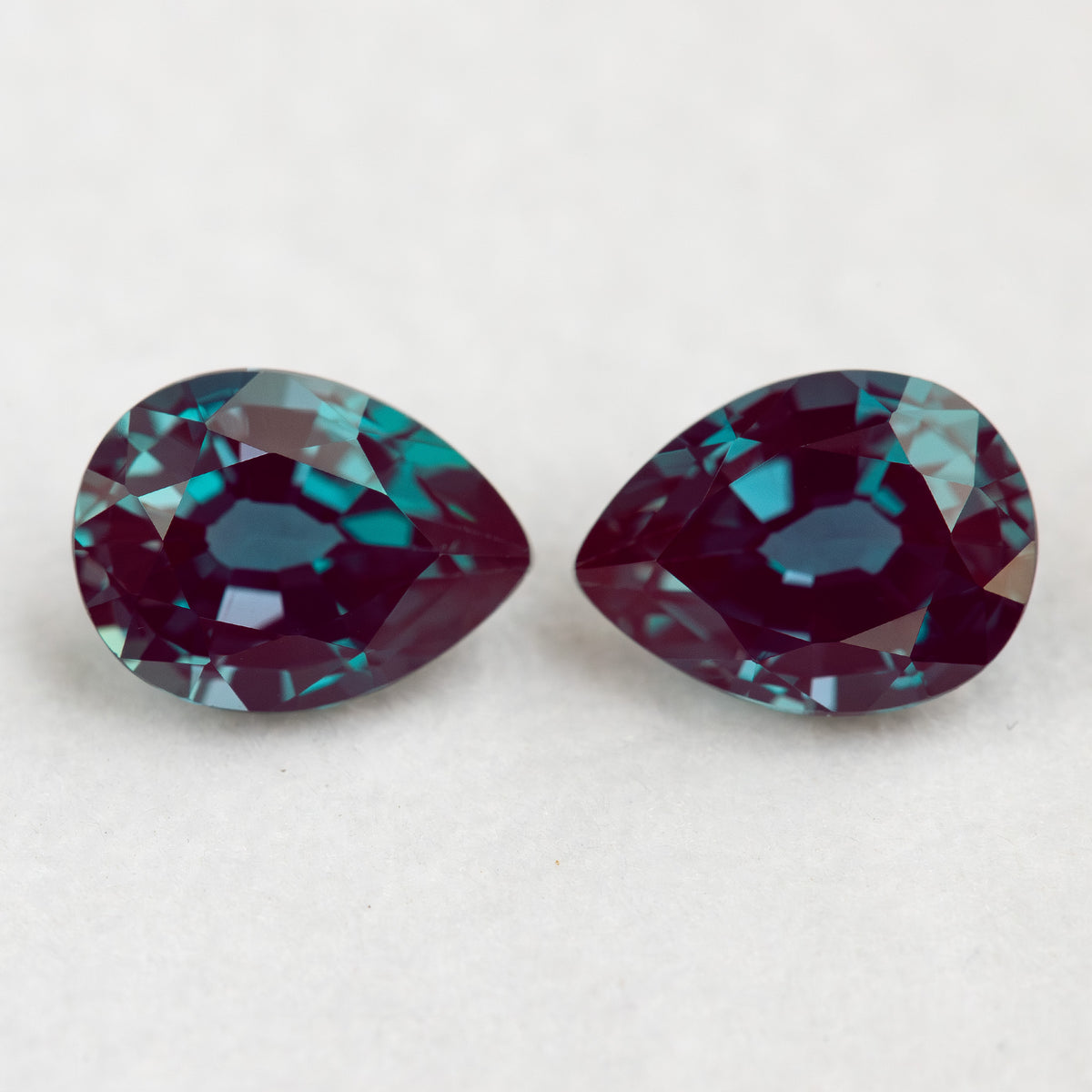 Two crown-facing pear lab-grown alexandrite samples side by side, illustrating the pair purchase option.