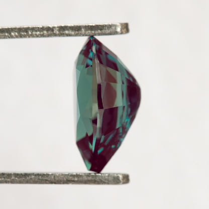 Side profile of the pear sample in tweezers, showing its crown and pavilion depth.
